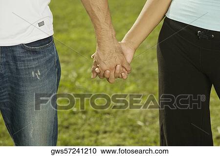 Mid section view of a man and a woman holding hands View Large Photo Image Stock Image - Mid section view of a man and a woman holding hands. Fotosearch