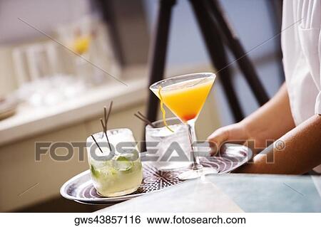 Mid section view of a man carrying cocktails on a tray View Large Photo Image Stock Photograph - Mid section view of a man carrying cocktails on a tray. Fotosearch