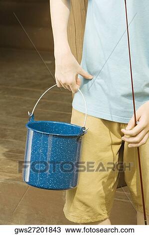 Mid section view of a man holding a fishing rod and a bucket View Large Photo Image Stock Image - Mid section view of a man holding a fishing rod and a bucket. Fotosearch