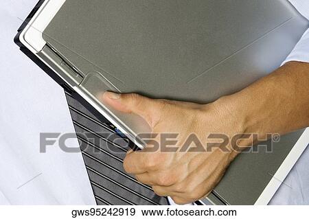 Mid section view of a man holding a laptop View Large Photo Image Stock Photo - Mid section view of a man holding a laptop. Fotosearch