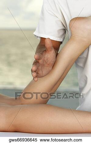Mid section view of a man massaging a woman's leg View Large Photo Image Stock Photography - Mid section view of a man massaging a woman's leg. Fotosearch