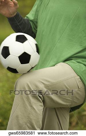 Mid section view of a man playing with a soccer ball View Large Photo Image Stock Image - Mid section view of a man playing with a soccer ball. Fotosearch