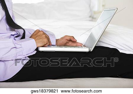 Mid section view of a mid adult man using a laptop View Large Photo Image Stock Image - Mid section view of a mid adult man using a laptop. Fotosearch