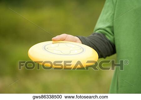 Mid section view of a person holding a plastic disc View Large Photo Image Stock Image - Mid section view of a person holding a plastic disc. Fotosearch