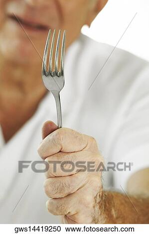 Mid section view of a senior man holding a fork View Large Photo Image Stock Image - Mid section view of a senior man holding a fork. Fotosearch
