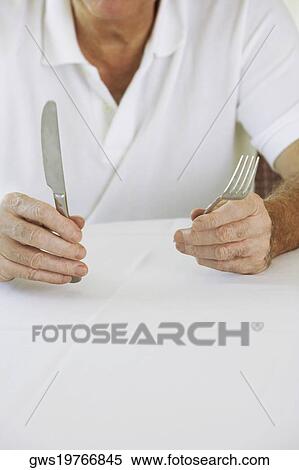 Mid section view of a senior man holding a table knife and a fork View Large Photo Image Stock Photography - Mid section view of a senior man holding a table knife and a fork. Fotosearch
