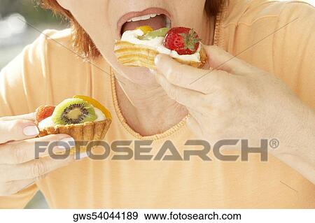 Mid section view of a senior woman eating a strawberry tart View Large Photo Image Stock Photo - Mid section view of a senior woman eating a strawberry tart. Fotosearch