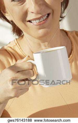 Mid section view of a senior woman holding a cup of coffee View Large Photo Image Stock Photo - Mid section view of a senior woman holding a cup of coffee. Fotosearch