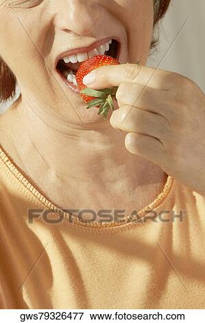 Mid section view of a senior woman eating a strawberry View Large Photo Image Stock Photo - Mid section view of a senior woman eating a strawberry. Fotosearch