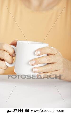 Mid section view of a senior woman holding a coffee cup View Large Photo Image Stock Photography - Mid section view of a senior woman holding a coffee cup. Fotosearch