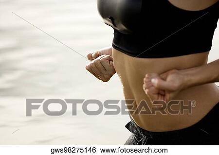Mid section view of a woman exercising in water View Large Photo Image Stock Photograph - Mid section view of a woman exercising in water. Fotosearch