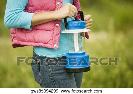 Mid section view of a woman holding a lantern View Large Photo Image Stock Photo - Mid section view of a woman holding a lantern. Fotosearch