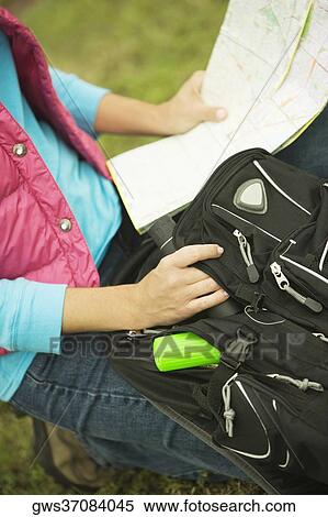 Mid section view of a woman holding a map and a backpack View Large Photo Image Stock Photography - Mid section view of a woman holding a map and a backpack. Fotosearch