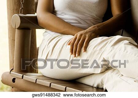 Mid section view of a woman sitting on a porch swing View Large Photo Image Stock Image - Mid section view of a woman sitting on a porch swing. Fotosearch