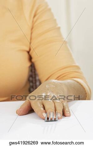 Stock Photo - Mid section view of a woman with her hand on a fork. Fotosearch