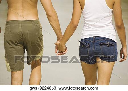 Mid section view of a young man and a teenage girl holding hands View Large Photo Image Stock Image - Mid section view of a young man and a teenage girl holding hands. Fotosearch