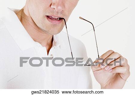 Mid section view of a young man holding eyeglasses View Large Photo Image Stock Photography - Mid section view of a young man holding eyeglasses. Fotosearch