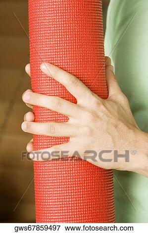 Mid section view of a young man's hand holding a rolled up exercise mat View Large Photo Image Stock Photo - Mid section view of a young man's hand holding a rolled up exercise mat. Fotosearch