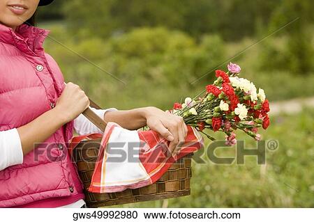 Mid section view of a young woman holding a basket of flowers View Large Photo Image Stock Image - Mid section view of a young woman holding a basket of flowers. Fotosearch
