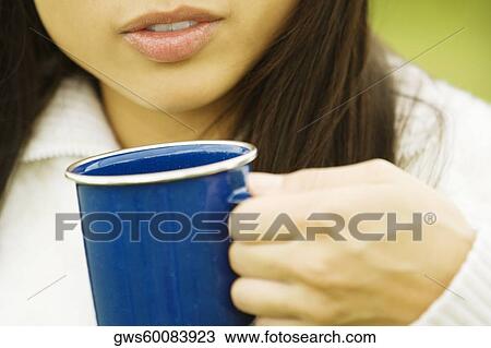 Mid section view of a young woman holding a cup of coffee View Large Photo Image Stock Image - Mid section view of a young woman holding a cup of coffee. Fotosearch