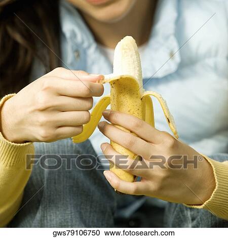 Mid section view of a young woman peeling a banana View Large Photo Image Stock Image - Mid section view of a young woman peeling a banana. Fotosearch