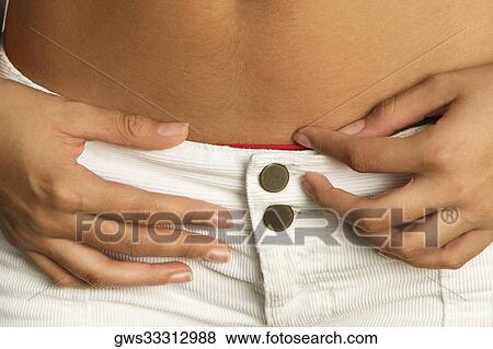 Mid section view of a young woman View Large Photo Image Stock Photo - Mid section view of a young woman. Fotosearch