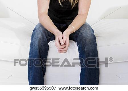 Mid section view of a young woman sitting on the bed View Large Photo Image Stock Photo - Mid section view of a young woman sitting on the bed. Fotosearch