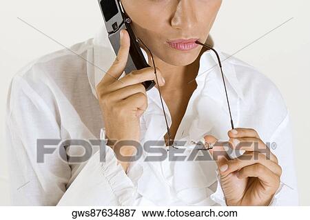 Mid section view of a young woman talking on a mobile phone View Large Photo Image Stock Photo - Mid section view of a young woman talking on a mobile phone. Fotosearch