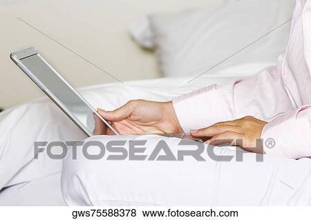 Mid section view of a young woman using a laptop View Large Photo Image Stock Photo - Mid section view of a young woman using a laptop. Fotosearch
