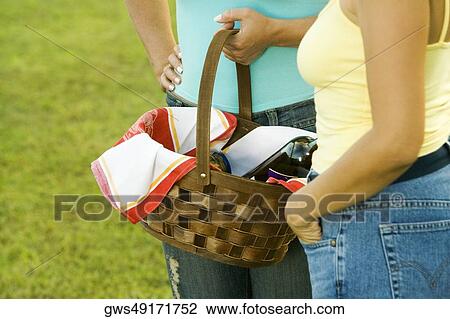 Mid section view of two women holding a picnic basket View Large Photo Image Stock Image - Mid section view of two women holding a picnic basket. Fotosearch