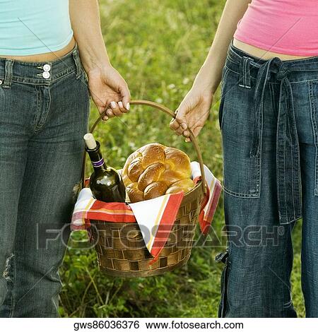 Mid section view of two women holding a picnic basket View Large Photo Image Stock Photograph - Mid section view of two women holding a picnic basket. Fotosearch