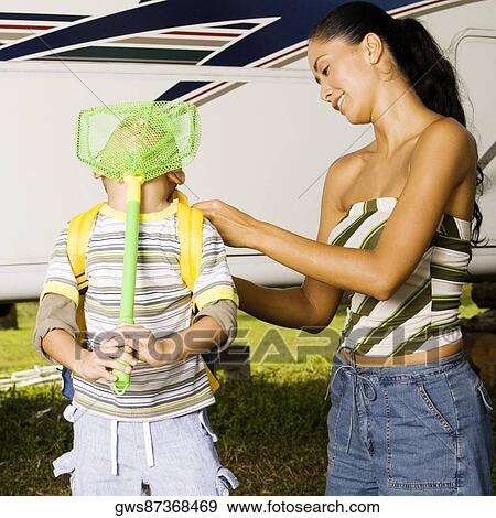 Stock Photo - Mother adjusting her son's backpack. Fotosearch