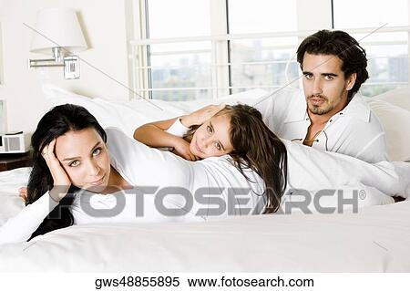 Parents with their daughter on the bed View Large Photo Image Stock Photography - Parents with their daughter on the bed. Fotosearch