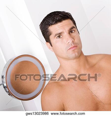 Stock Photograph - Portrait of a bare chested mid adult man looking serious. Fotosearch