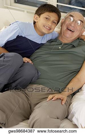 Stock Photo - Portrait of a boy and his grandfather on a couch. Fotosearch