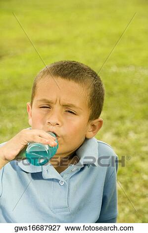 Portrait of a boy drinking beverage from a bottle View Large Photo Image Stock Photo - Portrait of a boy drinking beverage from a bottle. Fotosearch