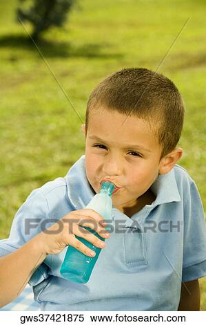 Stock Photography - Portrait of a boy drinking beverage from a bottle. Fotosearch