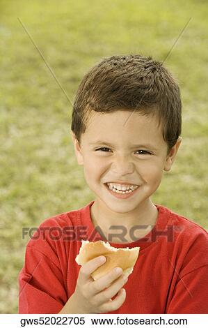 Portrait of a boy holding a burger View Large Photo Image Stock Photography - Portrait of a boy holding a burger. Fotosearch