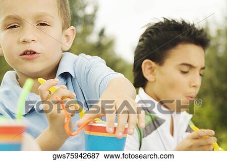 Portrait of a boy holding a disposable cup View Large Photo Image Stock Photo - Portrait of a boy holding a disposable cup. Fotosearch