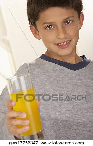 Portrait of a boy holding a glass of juice View Large Photo Image Stock Photo - Portrait of a boy holding a glass of juice. Fotosearch