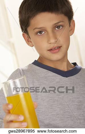 Portrait of a boy holding a glass of juice View Large Photo Image Stock Photography - Portrait of a boy holding a glass of juice. Fotosearch