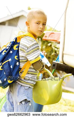 Portrait of a boy holding a watering can View Large Photo Image Stock Image - Portrait of a boy holding a watering can. Fotosearch
