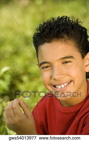 Stock Photo - Portrait of a boy holding a wildflower. Fotosearch