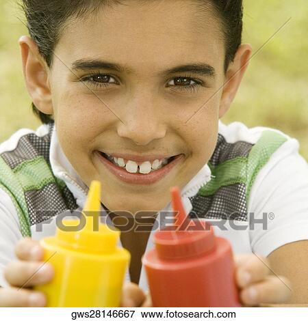Portrait of a boy holding two sauce bottles View Large Photo Image Stock Photo - Portrait of a boy holding two sauce bottles. Fotosearch