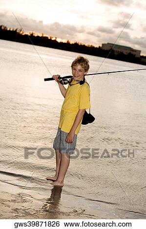 Portrait of a boy smiling carrying a fishing rod View Large Photo Image Stock Photograph - Portrait of a boy smiling carrying a fishing rod. Fotosearch