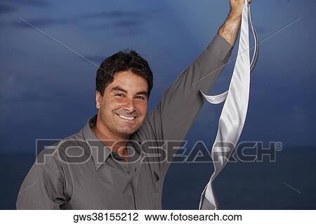 Portrait of a businessman holding a tie in his raised hand View Large Photo Image Stock Image - Portrait of a businessman holding a tie in his raised hand. Fotosearch
