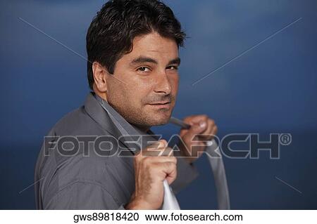 Portrait of a businessman holding a tie around his neck View Large Photo Image Stock Image - Portrait of a businessman holding a tie around his neck. Fotosearch