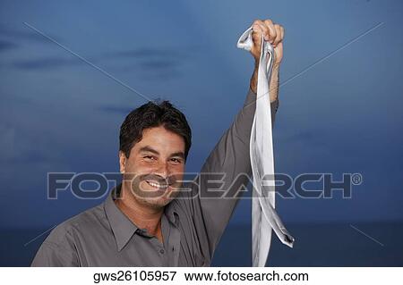Portrait of a businessman holding a tie in his raised hand View Large Photo Image Stock Photo - Portrait of a businessman holding a tie in his raised hand. Fotosearch