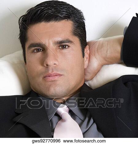 Stock Photograph - Portrait of a businessman relaxing with his hand behind his head. Fotosearch