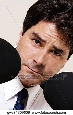 Stock Photo - Portrait of a businessman wearing boxing gloves. Fotosearch